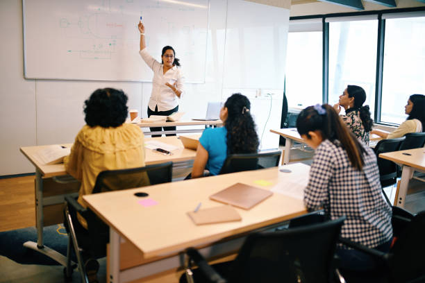 Mature Adult students listening to the instructor teaching in the classroom on white board, Advance education
